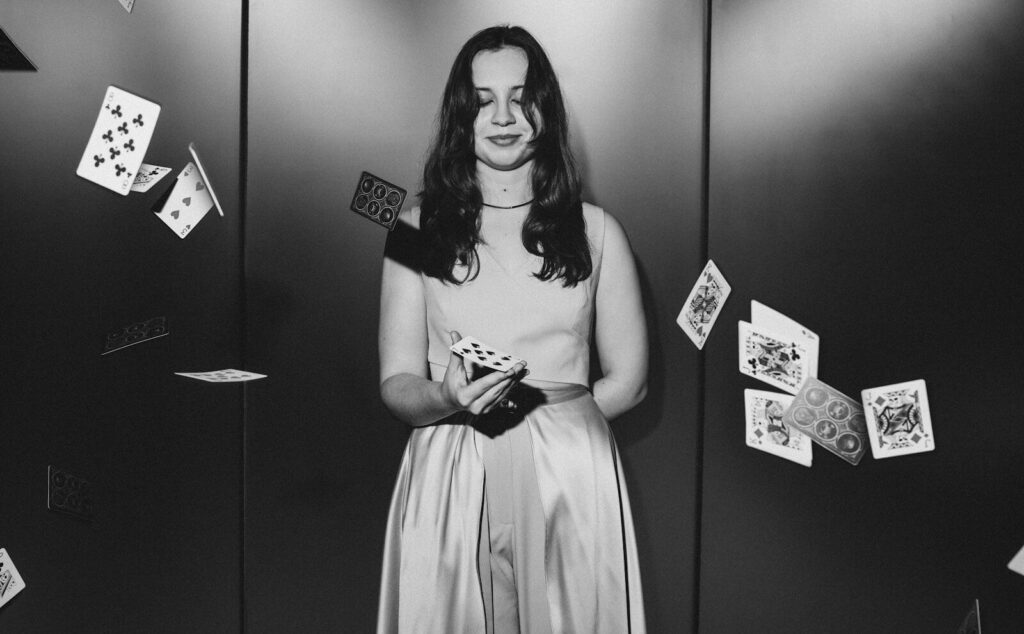 A young woman with cards falling around her