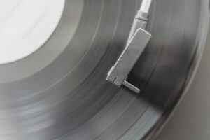 A turntable needle plays a vinyl record.