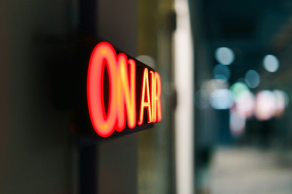 Red "on air" sign glowing in the dark
